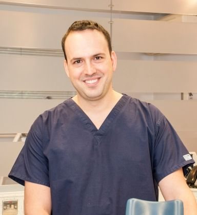 Angel Ognemirov, endodontist, in clinical scrubs at the dental practice